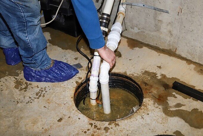 a Saanch plumber inspecting a sump pump for Saanich plumbing services