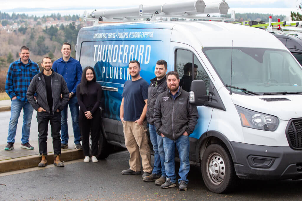 Our Plumbers stand in front of a service truck, ready to head to a local project site.